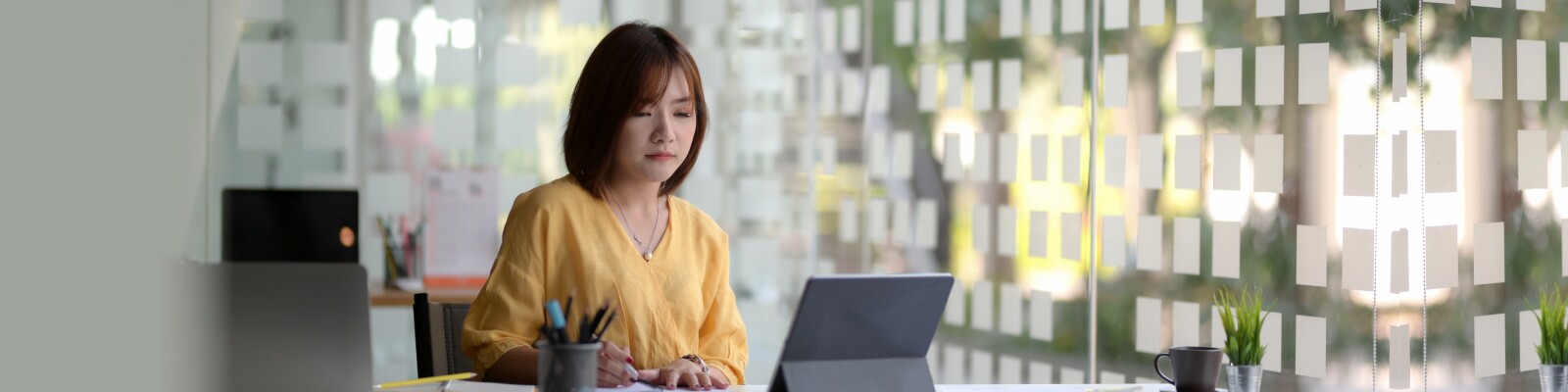 Woman sits in an office by the window