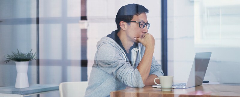 Man focused on a laptop, concentrating