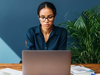 focused woman working on laptop at her desk