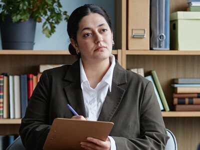 Female counselor listening attentively to teenage boy during counseling session