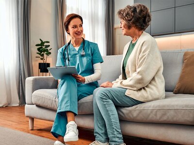 geriatric care nurse sitting in session with elderly female patient