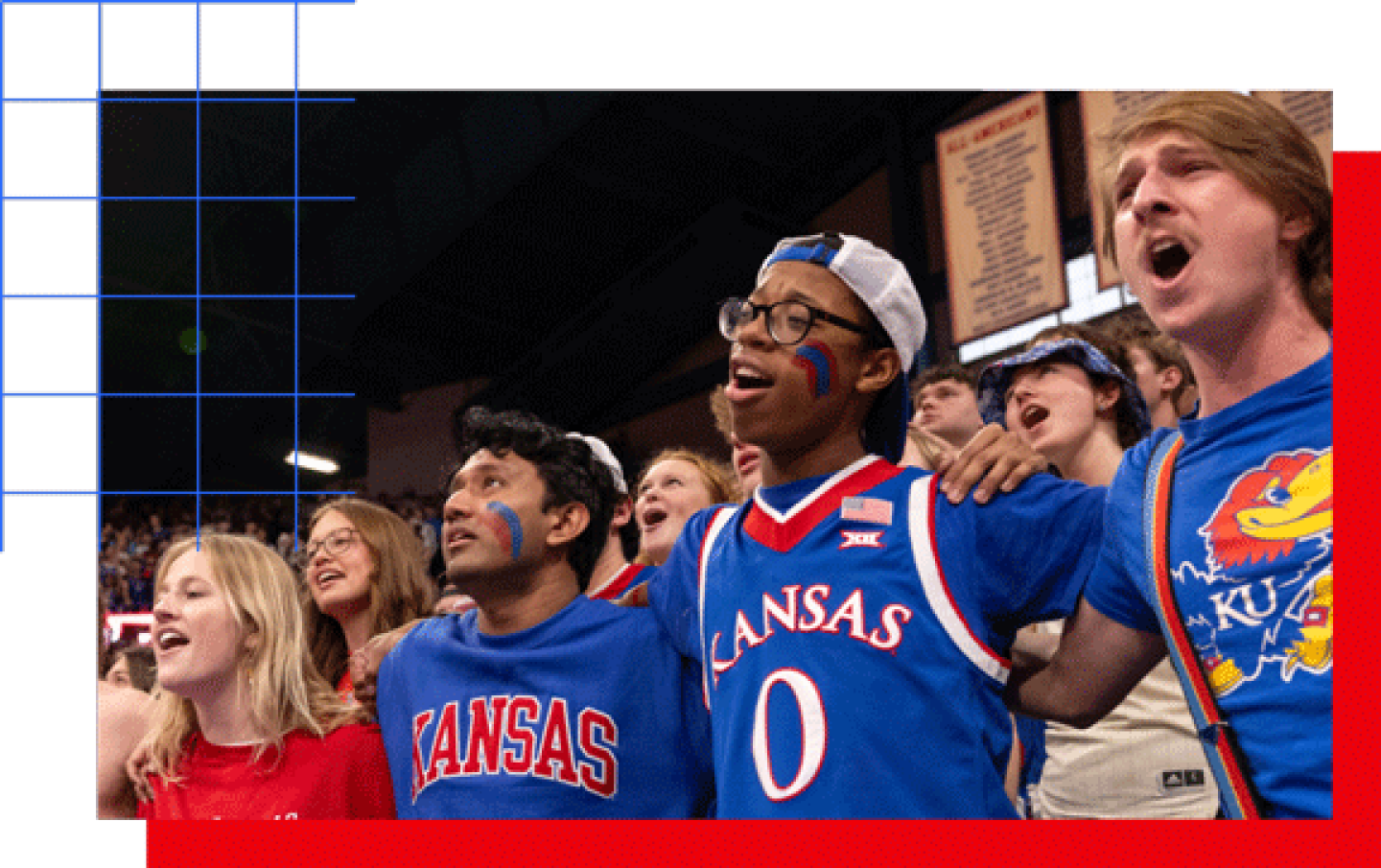 Kansas Jayhawks fans standing arm-in-arm in a crowded arena wearing blue KU shirts and face paint.