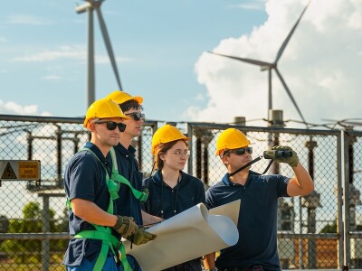 Wind energy engineering team inspecting high-voltage substation infrastructure at renewable power plant