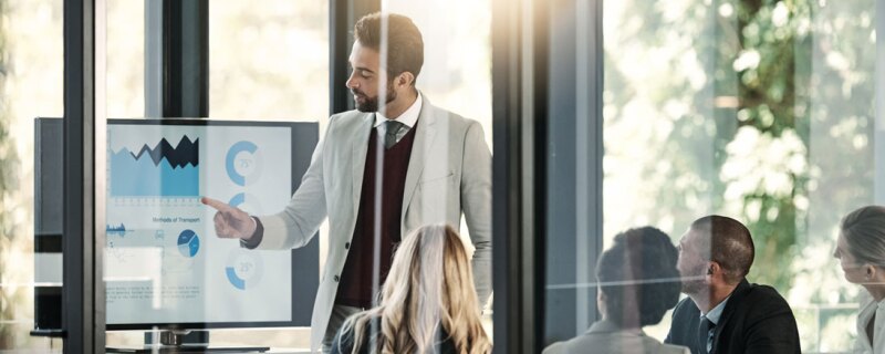 man pointing to screen with charts