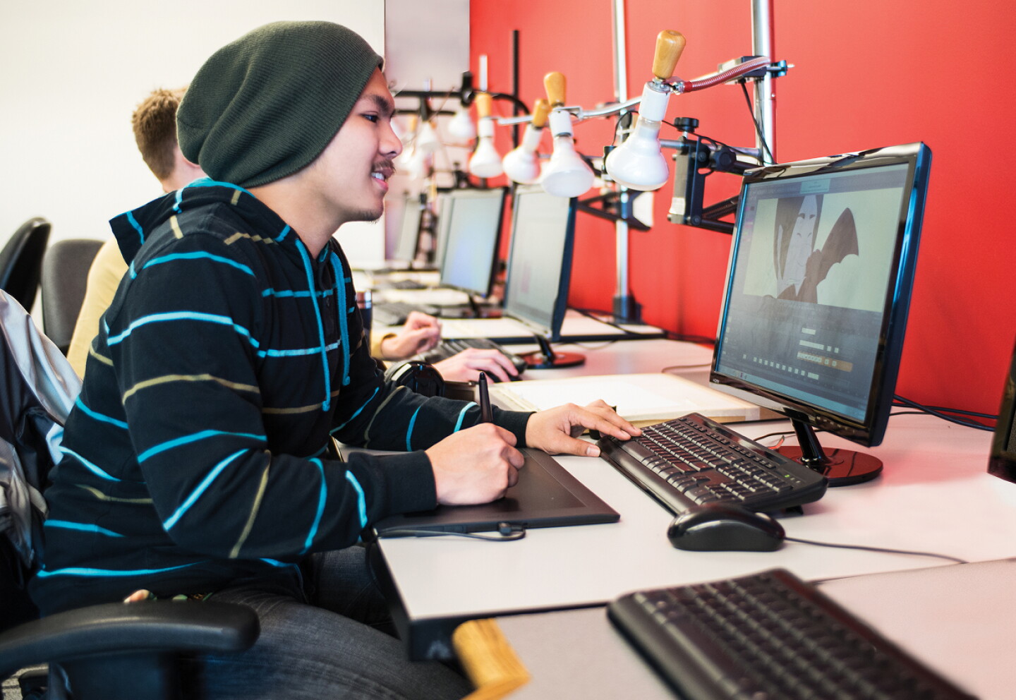 Student using a digital drawing tablet in a classroom setting.
