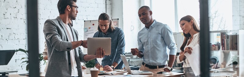 Team of four marketing professionals collaborating in a office on a strategic plan