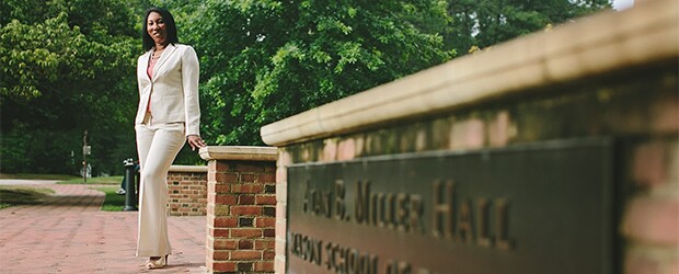 William & Mary MBA student standing in front of Alan B Miller Hall at William & Mary's campus