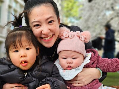 Pariya Rojitanongchai sitting with her two children in a university courtyard.