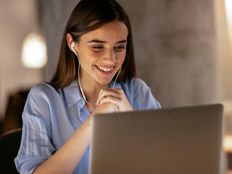 Student with headphones on her laptop