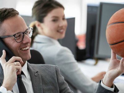 A businessman is talking on the phone in the office with a potential client.