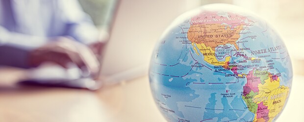 Globe-Of-The-World-With-Man-Working-On-Laptop