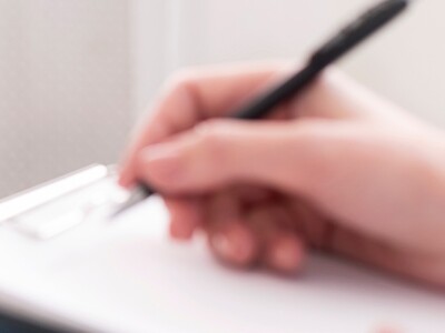 Counselor writing notes during a session with a man