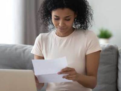 woman on sofa looking at MBA paperwork