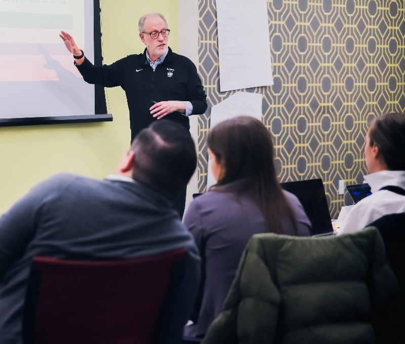 Nortrhwestern instructor leading a lecture and gesturing to projection screen