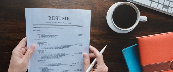 Paper resume on the desk next to coffee cup