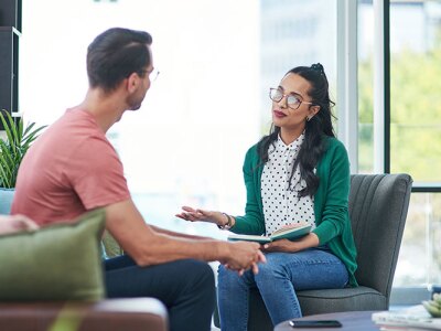 female mental health professional and client sitting in a green room in session