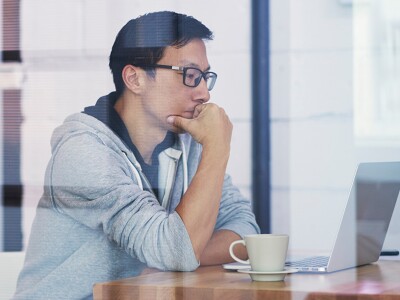 Man focused on a laptop, concentrating