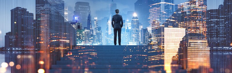 Executive at top of stairs overlooking cityscape