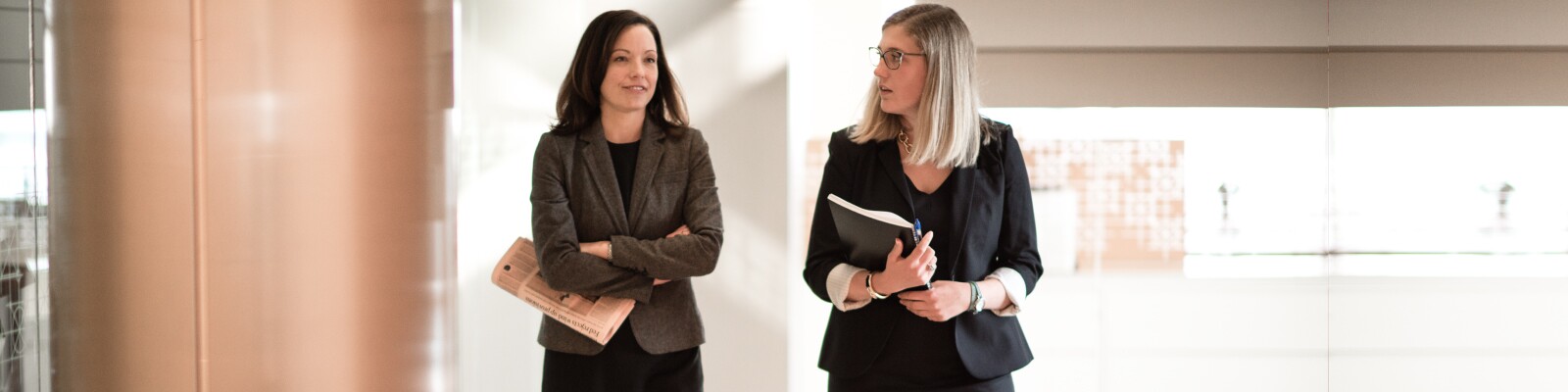 Two Marquette graduate business students walk the hallway together in conversation