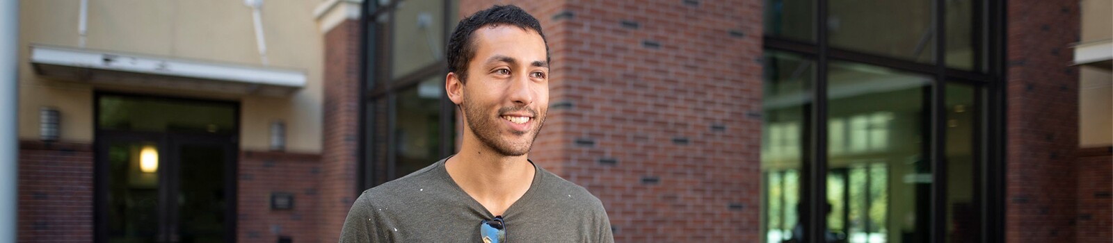 Chico state student smiling in front of building on campus