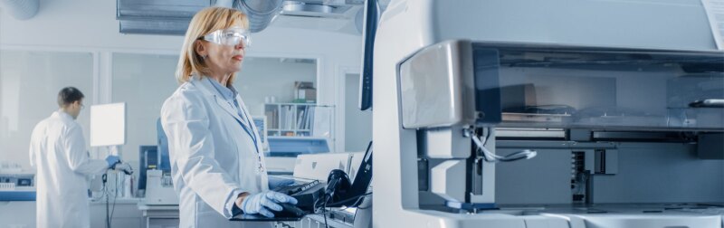 Female Scientists Programs Medical Equipment with Personal Computer.