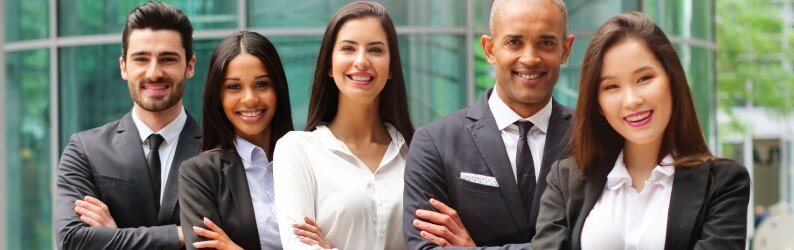 Group of multicultural educators smiling with arms crossed.