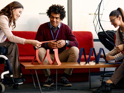 Multiracial business coworkers making house of cards on break in the office.