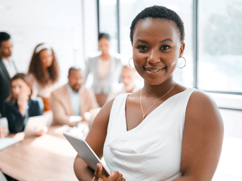 Woman smiling in front of colleagues at table
