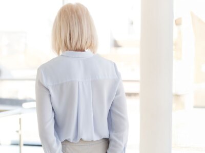 Rear view of nervous, middle-aged business woman applicant waiting for job interview