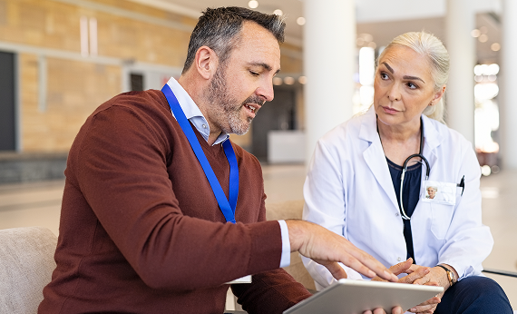 Man speaking with a medical professional over a chart