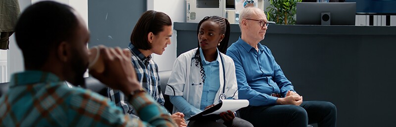 woman healthcare professional talking with man in a waiting room