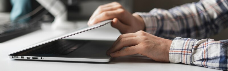 Man opens laptop computer to begin work