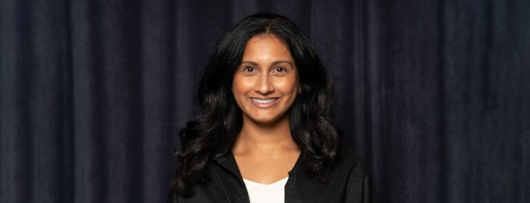 Northwestern IMC student smiling in front of a black curtain