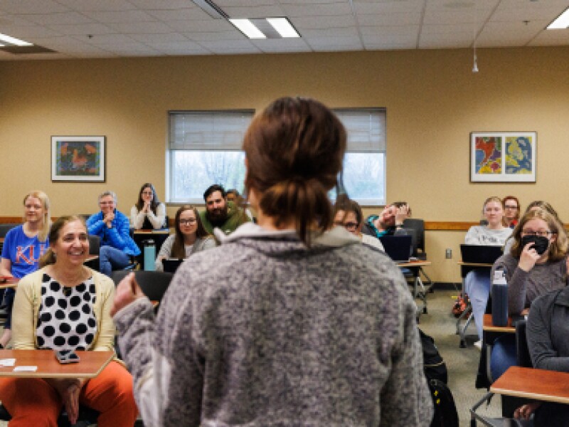 A from-behind shot of a female KU professor addressing her classroom.