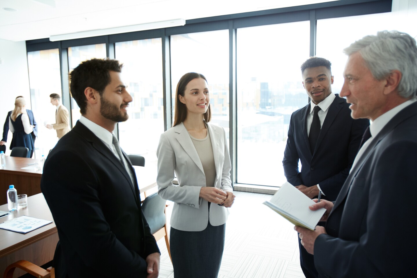 Two people listen to senior member providing advice