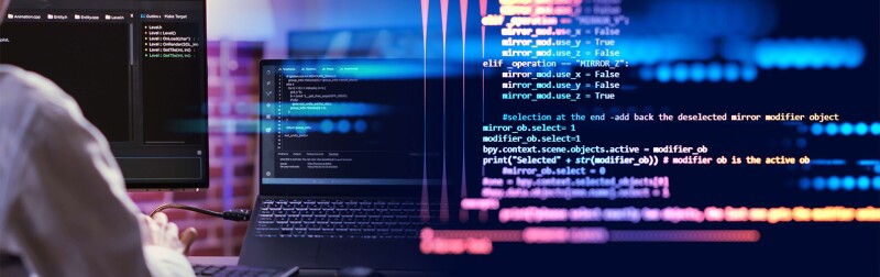 Programmer in front of desktop computer writing code