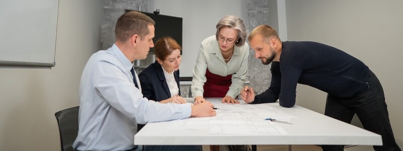Four colleagues review plans in a meeting