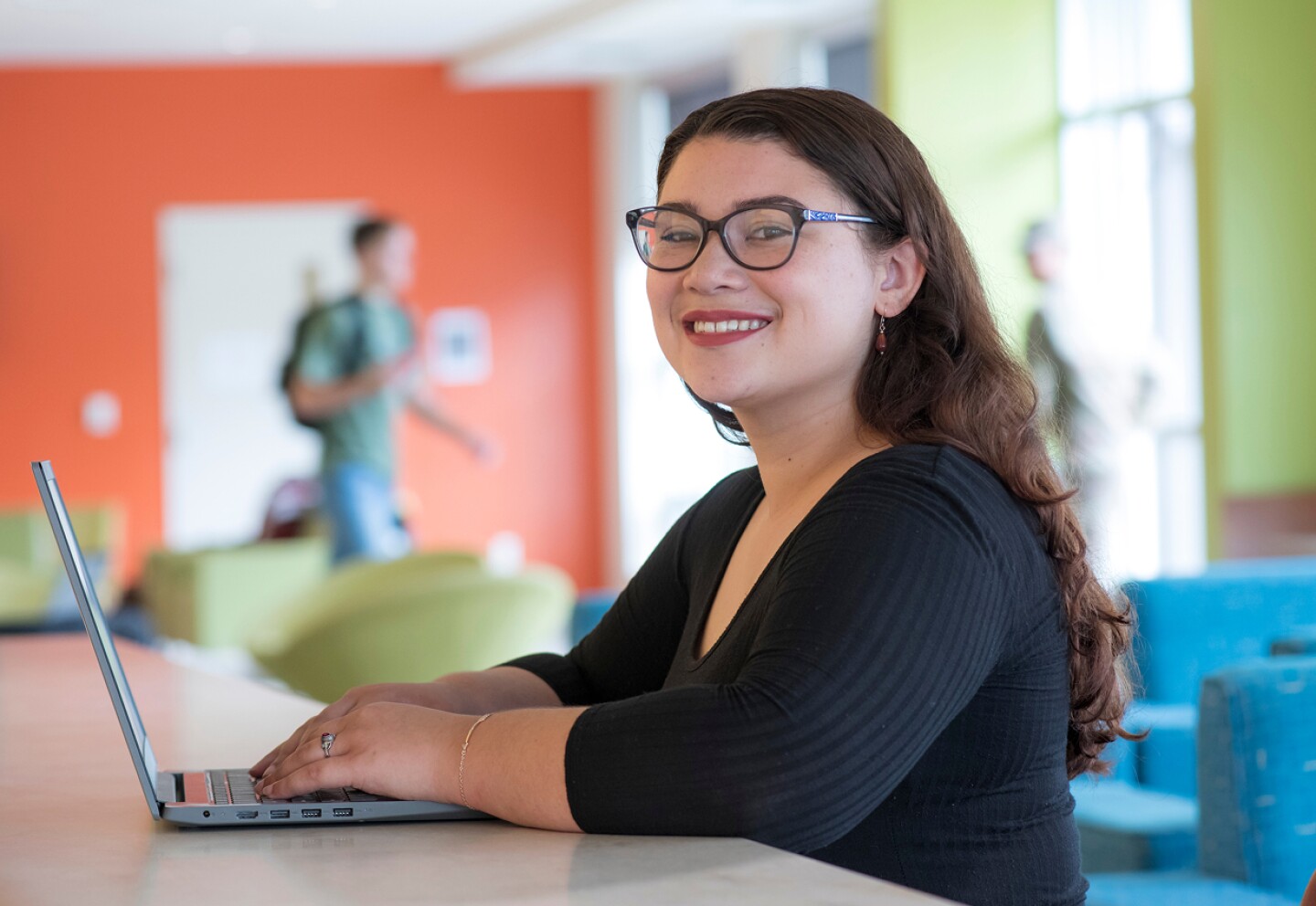 Smiling female student working on her laptop