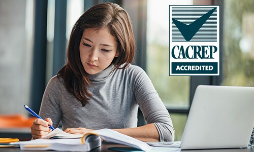 Young woman writing and studying with open books
