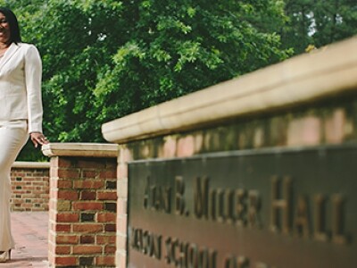 William & Mary MBA student standing in front of Alan B Miller Hall at William & MAry's campus