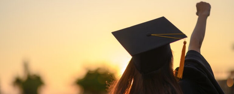 Woman in graduation cap and gown thinking about how to get letters of recommendation after graduation