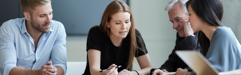 Business people in meeting reviewing paperwork