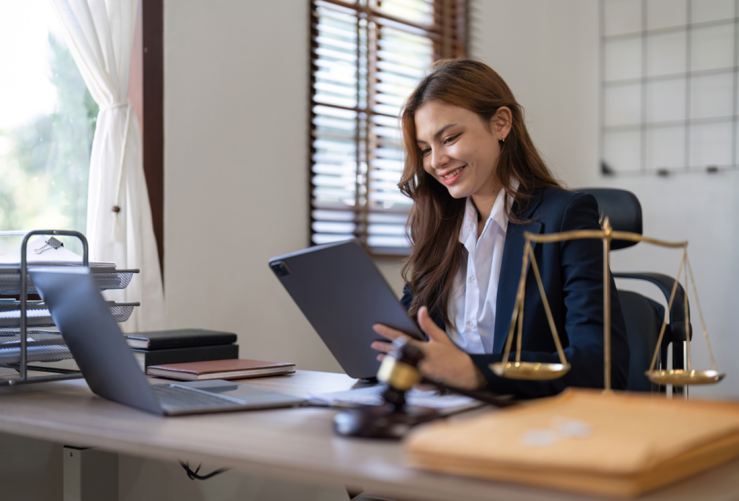 business woman with a tablet and laptop working in a home office