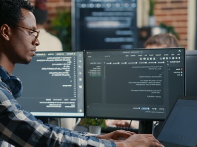 Man on computer typing code