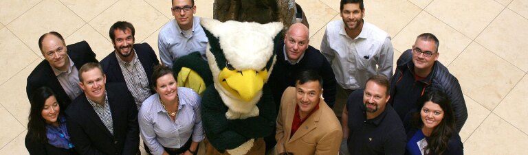 a group of students standing together around a mascot smiling