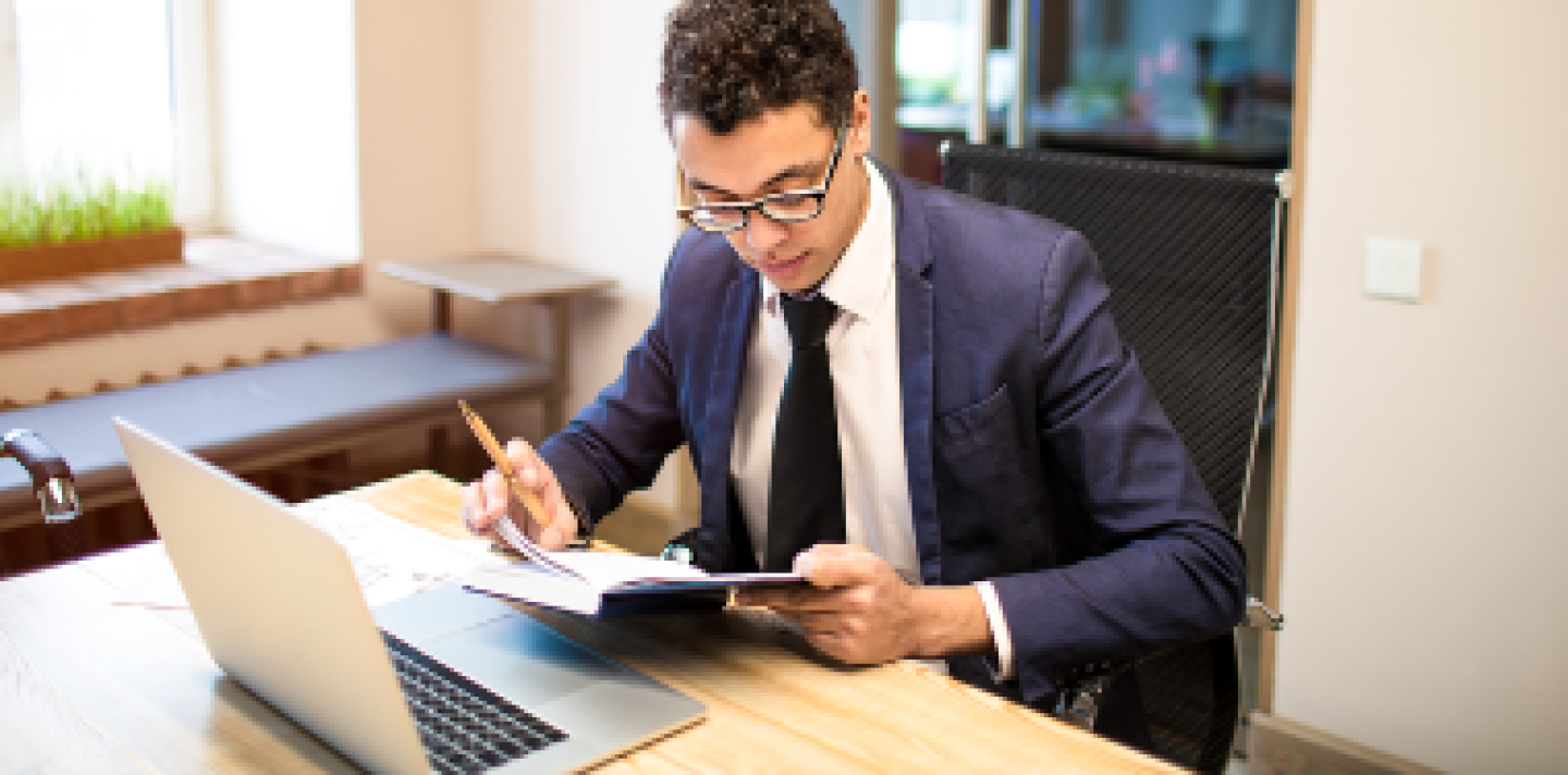 man wearing a tie in his office working on a project