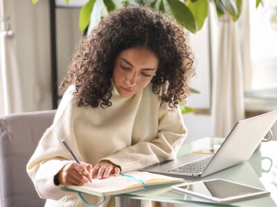 Young female student using laptop at home office using laptop for online learning.