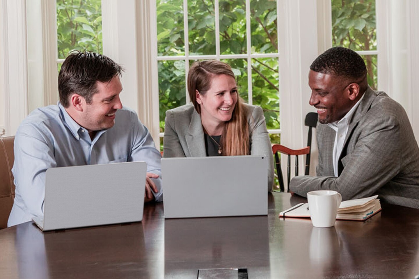 Three William & Mary student having a discussion at a large table