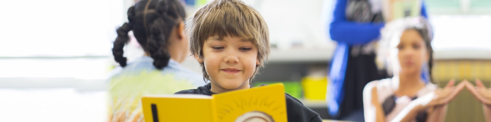 Boy reading a book and smiling