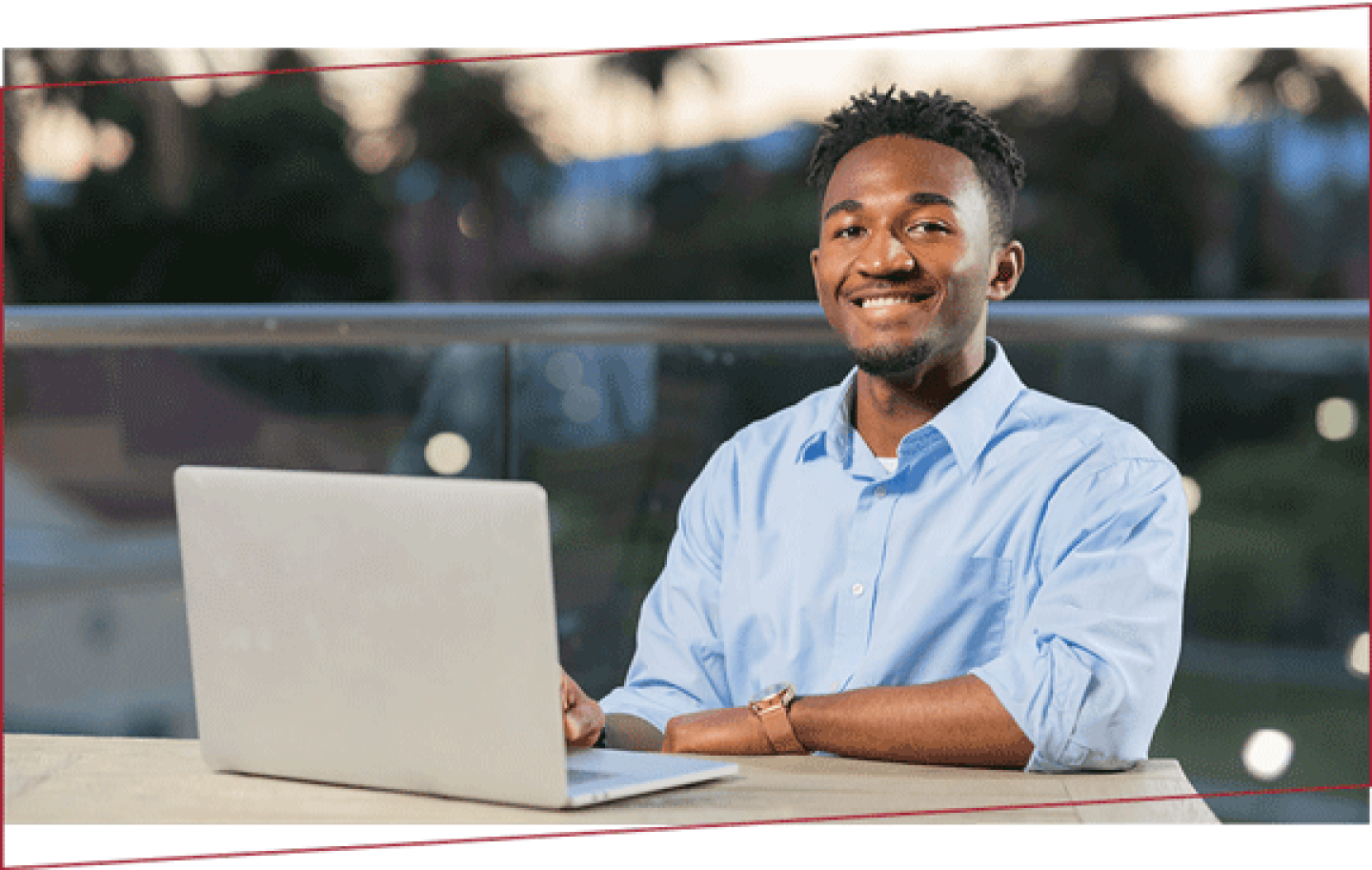 Smiling man seated with laptop